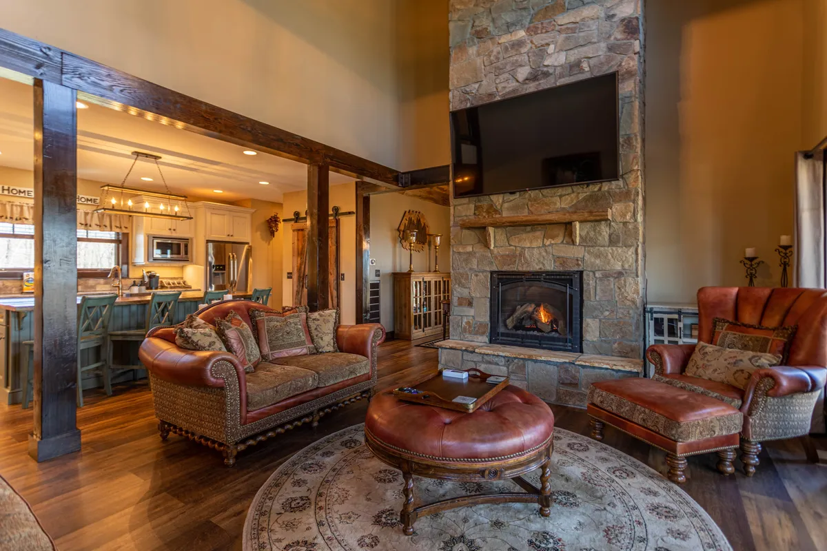 A living room scene featuring a fireplace, sofa set, coffee table, and a large TV, all arranged for communal activities. The mood is cozy and welcoming, perfect for movie nights or family gatherings.