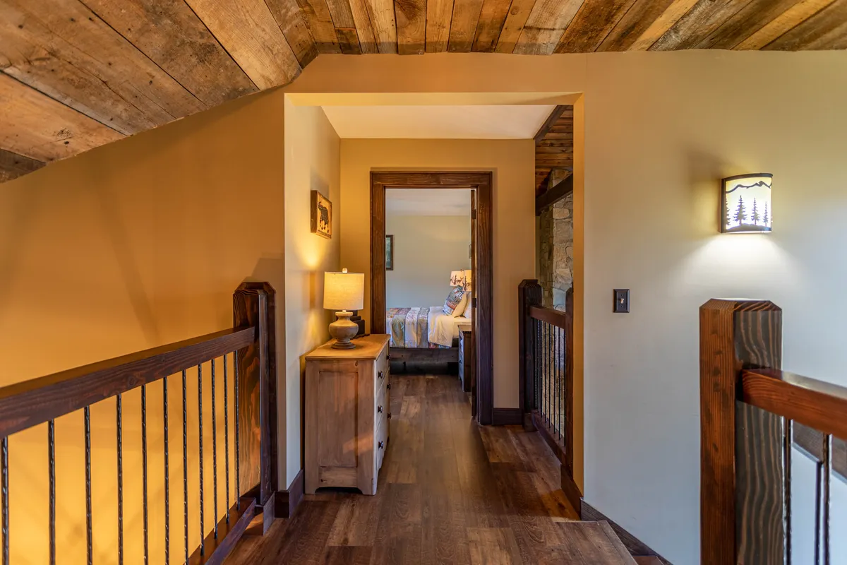 A cozy nook with crafted wooden railing, a warm lamp, and inviting wooden furniture, situated near a doorway. The space is designed for quiet relaxation, reading, or socializing after enjoying the community amenities.